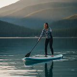 Frau paddelt auf einem ruhigen Bergsee mit dem Paddelwerk SUP-Board